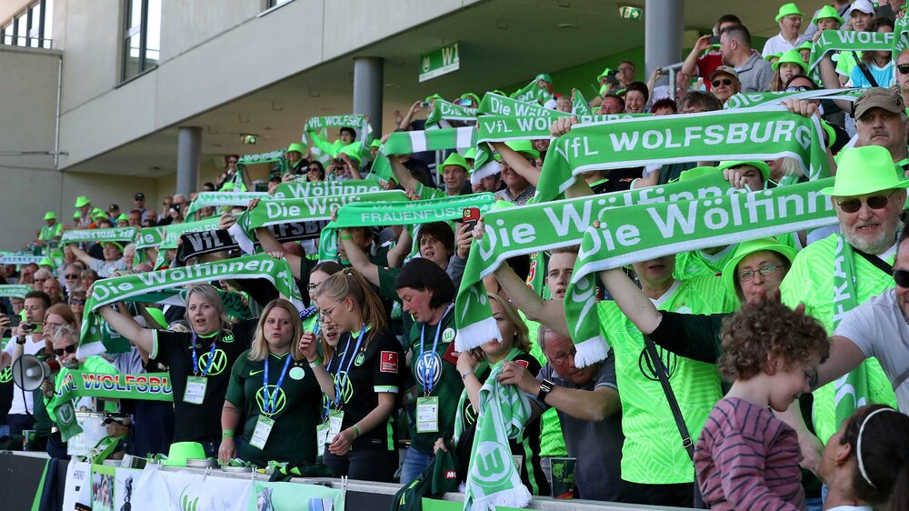 Fans der VfL-Wolfsburg Frauen schwenken Schals im AOK Stadion.