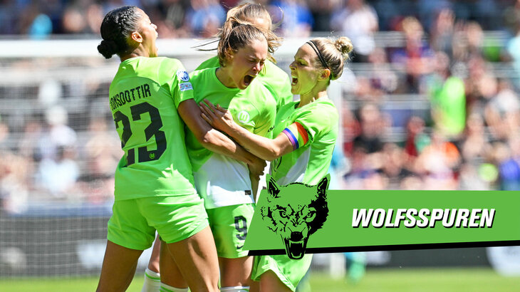 VfL Wolfsburg Spielerinnen umarmen sich auf dem Platz und jubeln frenetisch.