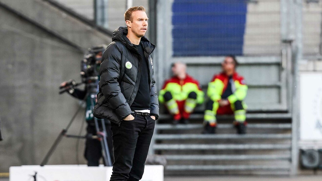 VfL-Wolfsburg-Trainer Tommy Stroot mit ernster Miene am Spielfeldrand.