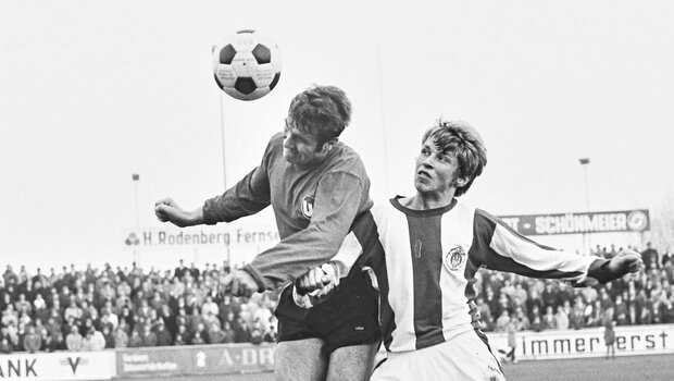 Ein historisches schwarz-weiß-Bild eines Zweikampfes um einen Kopfball bei einer Partie des VfL Wolfsburg gegen den FC St. Pauli.
