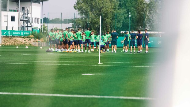 Die Mannschaft vom VfL Wolfsburg steht im Kreis auf dem Trainingsplatz.
