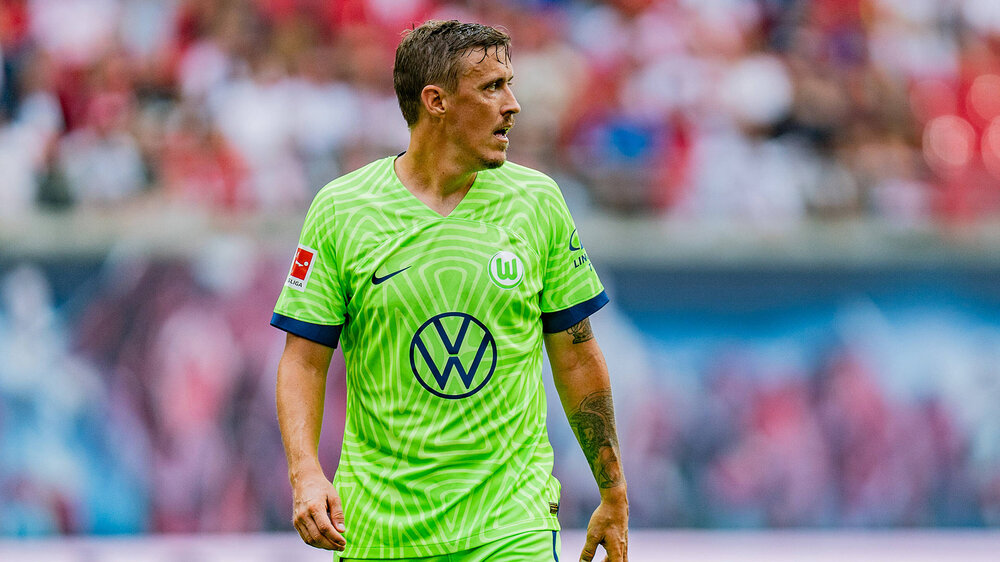 Max Kruse steht im VfL-Wolfsburg-Trikot auf dem Platz und schaut nach rechts.