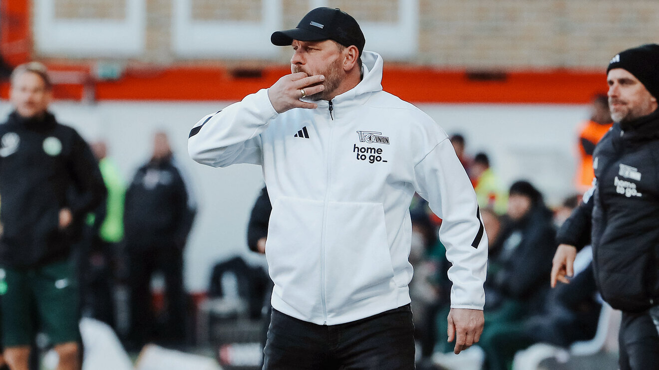 Union-Trainer Steffen Baumgart steckt zwei Finger in den Mund und pfeift.
