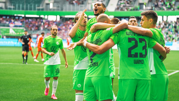 Spieler des VfL Wolfsburg jubeln ausgelassen zusammen.