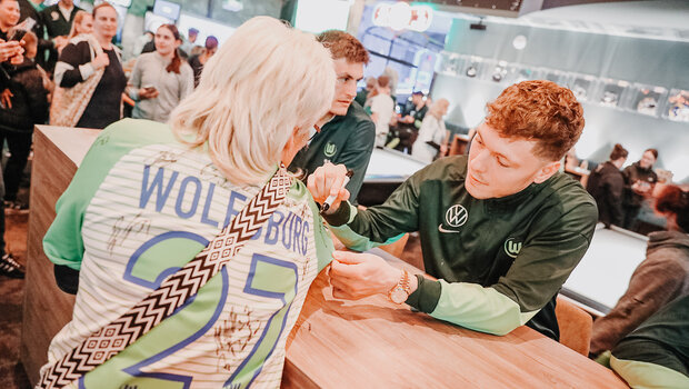 Andreas Skov Olsen unterzeichnet auf dem VfL Trikot einer Frau.