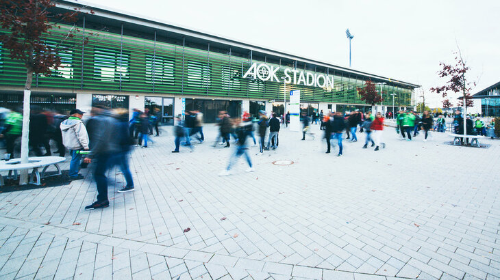 Die Fußballfans gehen zum AOK Stadion des VfL Wolfsburg.