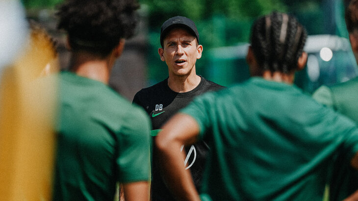 VfL-Wolfsburg-U19-Trainer Daniel Bauer spicht mit seinen Spielern.