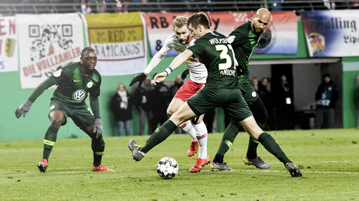 VfL Wolfsburg Spieler Knoche im Zweikampf mit einem Gegenspieler aus Leipzig um den Ball.