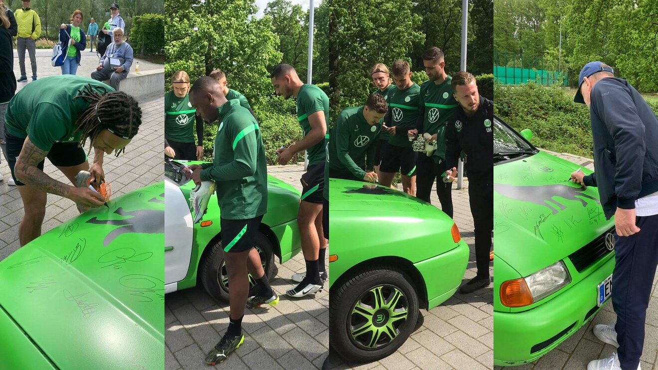 VfL-Wolfsburg-Spieler und Funktionäre unterschreiben auf einem VW Polo.