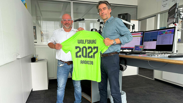 VfL Wolfsburg Geschäftsführer Meeske posiert mit dem Geschäftsführer von Radio 38.