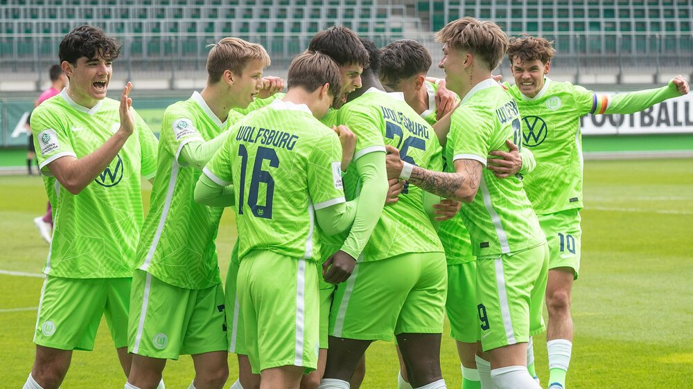 Die Spieler der U17-Mannschaft des VfL Wolfsburg stehen jubelnd beisammen. 
