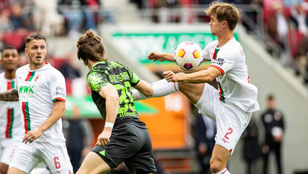 VfL-Wolfsburg-Spieler Wimmer bei einem Zweikampf im Spiel gegen Augsburg.