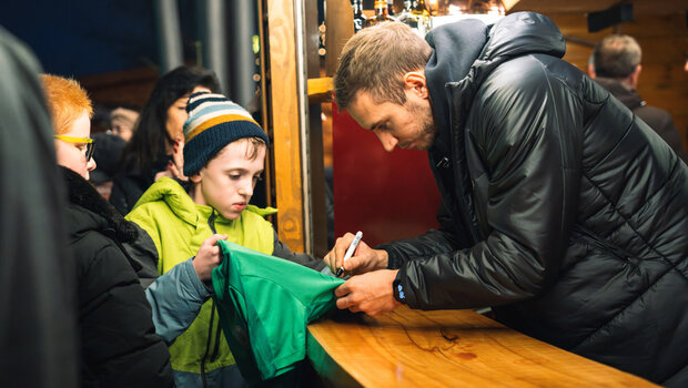 VfL-Wolfsburg-Torhüter Klinger gibt einem kleinen Fan ein Autogramm auf dem Weihnachtsmarkt.