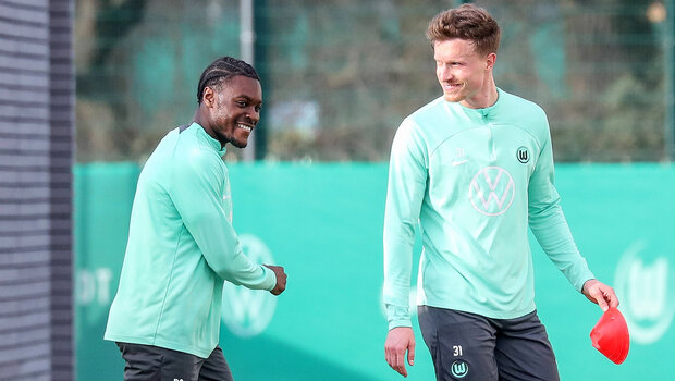 Ridle Baku und Ynnick Gerhardt vom VfL Wolfsburg lachen beim Training.