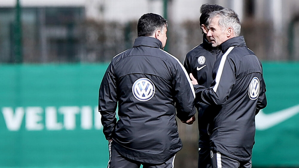 Athletiktrainer Günter Kern berät sich mit seinen Trainerkollegen beim VfL Wolfsburg.