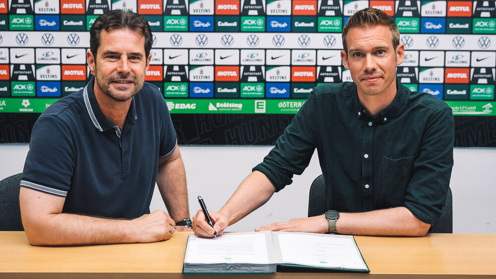 Sportlicher Leiter Ralf Kellermann und Trainer Tommy Stroot unterschreiben den Vertrag bis 2025 beim VfL Wolfsburg.