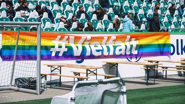 Die regenbogenfarbene Flagge mit der Aufschrift #Vielfalt hängt an der Tribüne beim Vielfalts Cup des VfL Wolfsburg.