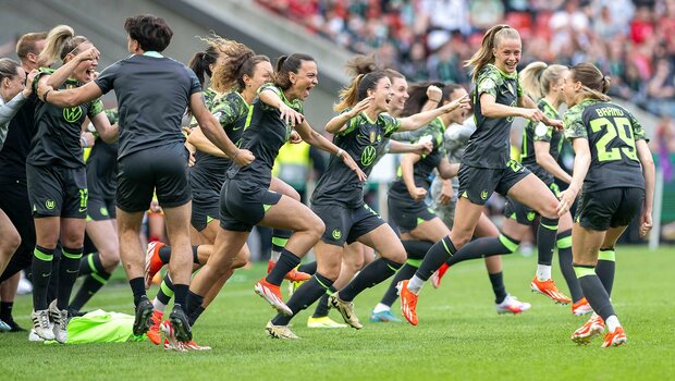 Die Spielerinnen des VfL Wolfsburg jubeln von der Bank aus über den Pokalsieg.