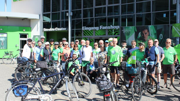 Die Mitglieder des WölfeClub 55Plus posieren vor ihrer Fahrradtour vor dem Fanhaus.