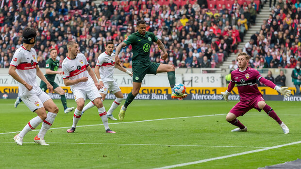 Wolfsburgs Angriffspieler Lukas Nmecha in der Luft im 16 Meter Raum.