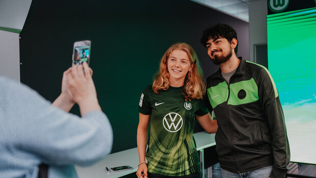 VfL-Wolfsburg-Spielerin Justine Kielland lächelt für ein Foto mit einem Fan.