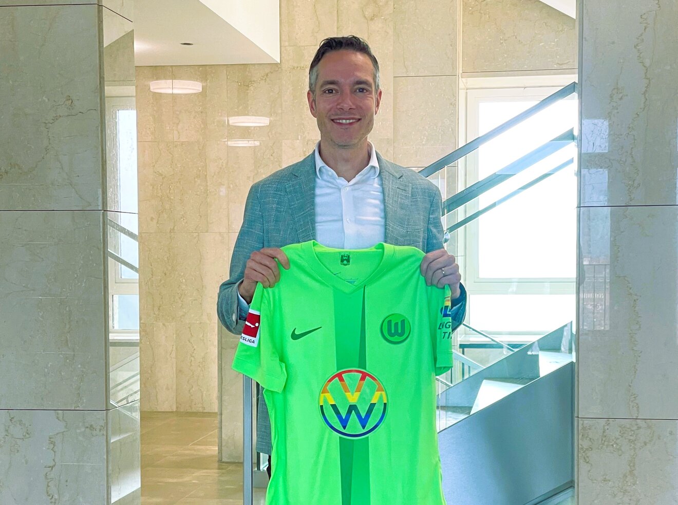 VfL-Wolfsburg-Aufsichtsrat-Mitglied Dr. Sebastian Rudolph hält das Vielfaltstrikot in der Hand.