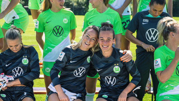 Die Torhüterinnen vom VfL Wolfsburg sitzen für das Mannschaftsfoto auf einer Bank.