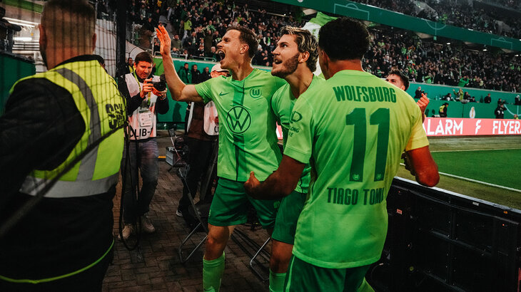 Die Spieler des VfL Wolfsburg jubeln nach dem gewonnenen Pokalspiel gegen Dortmund vor der Nordkurve mit den Fans.