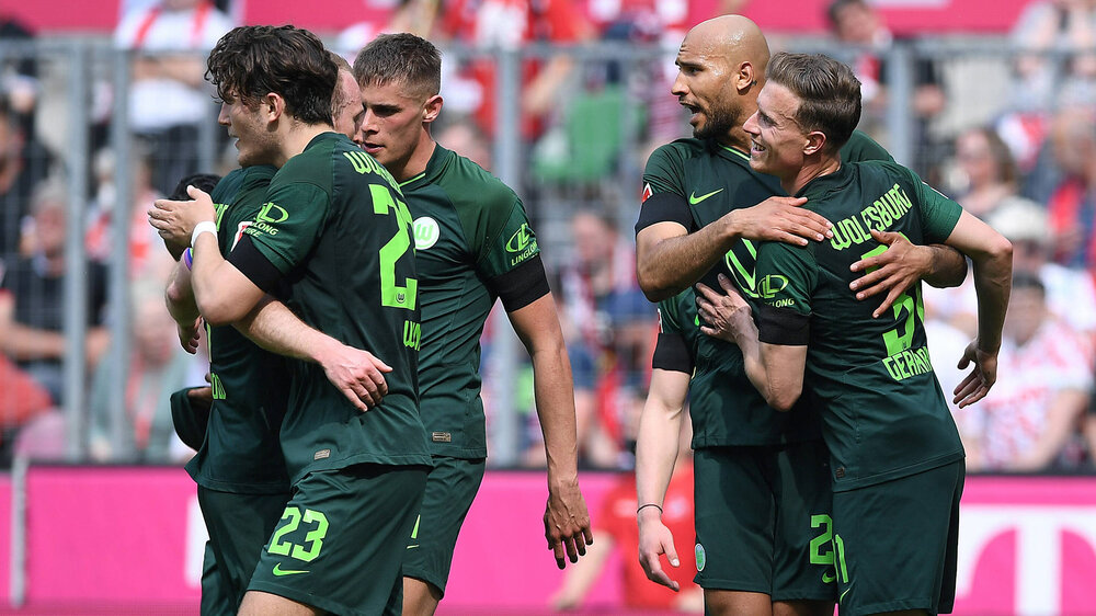 Die Spieler des VfL Wolfsburg umarmen sich und bejubeln ihren Treffer.