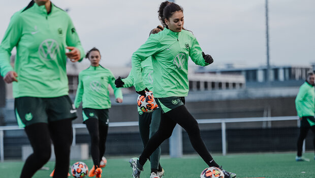 Trippeleinheit beim VfL-Wolfsburf-Trainingslager. Auf dem Platz sind Hütchen aufgebaut. Einige Spieler laufen mit dem Ball vor sich. 