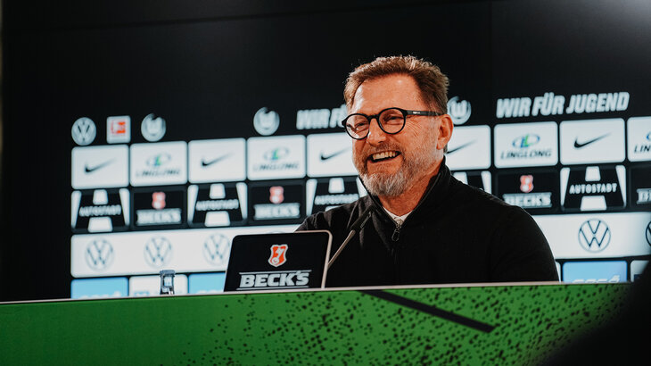 VfL-Trainer Ralph Hasenhüttl ist bei einer Pressekonferenz und lacht.