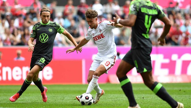 VfL-Wolfsburg-Spieler Majer und Lacroix im Zweikampf mit Luca Waldschmidt von Köln.