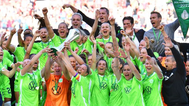 VfL-Wolfsburg-Spielerinnen strecken den DFB-Pokal in die Höhe.