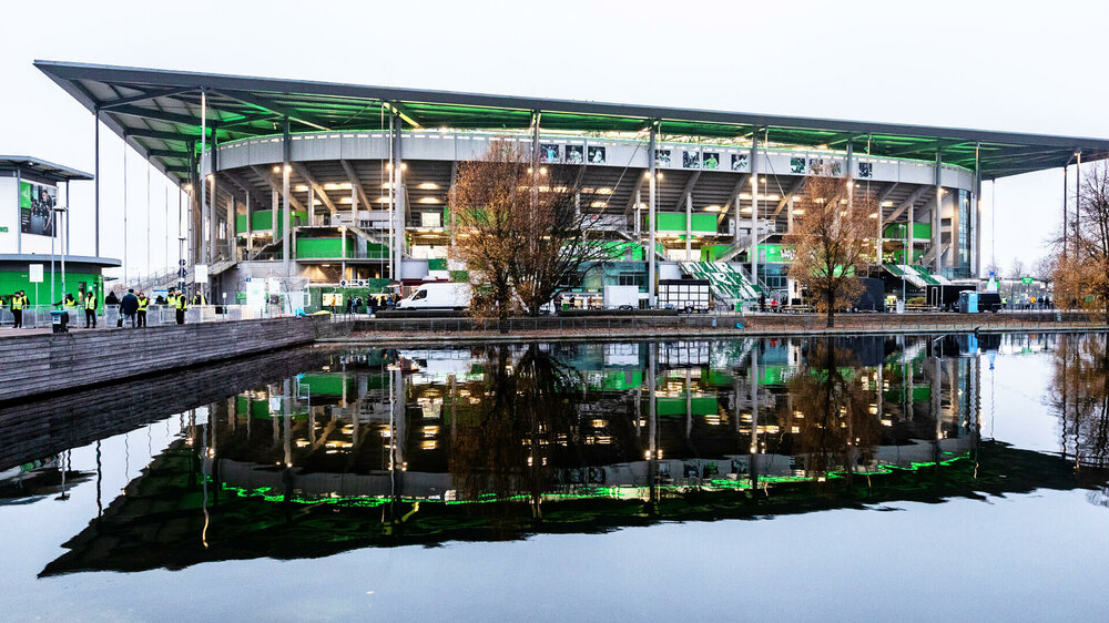 Dieses Bild  zeigt die Nordseite der Volkswagen Arena vom VfL Wolfsburg, die sich im Wasser spiegelt.