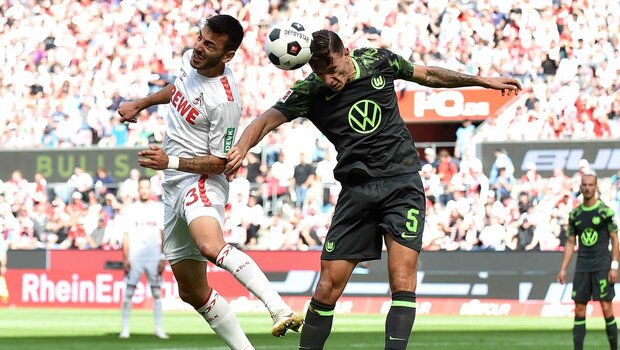 VfL-Wolfsburg-Spieler Zesiger im Zweikampf mit einem Köln Spieler.