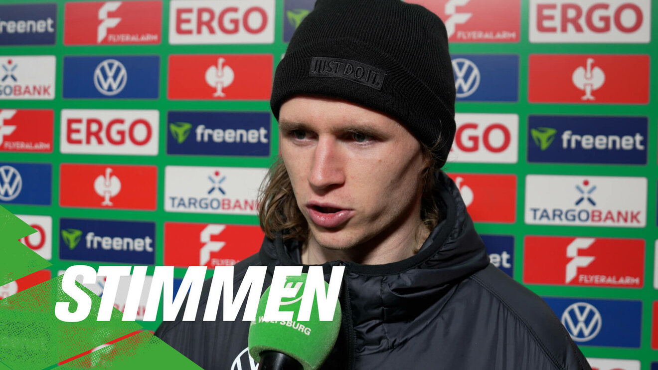 Der VfL-Wolfsburg-Spieler Patrick Wimmer spricht in ein Mikrofon.