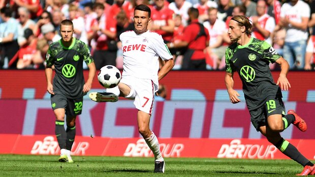 VfL-Wolfsburg-Spieler Majer und Svanberg im Zweikampf mit einem Köln Spieler.