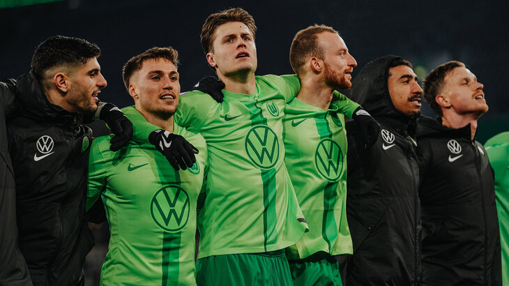 VfL-Wolfsburg-Spieler Mattias Svanberg steht Arm in Arm mit Mannschaftskollegen.
