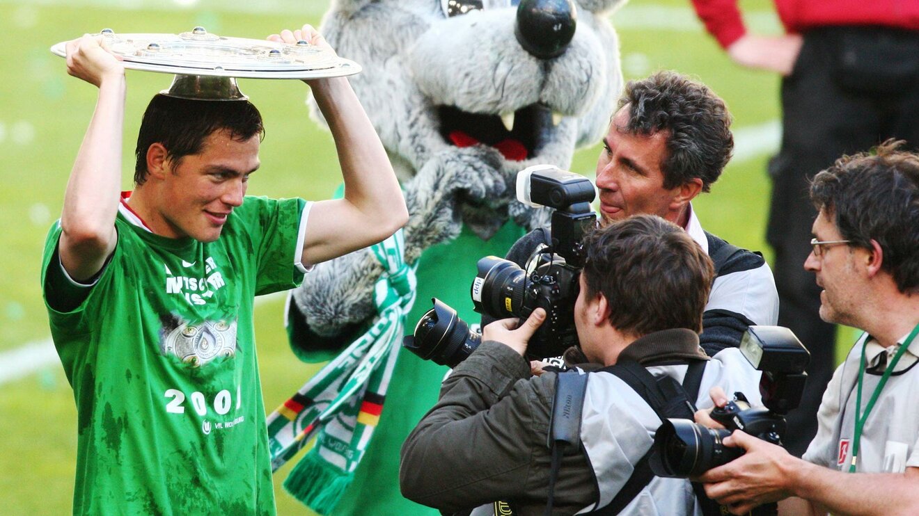 Der ehemalige Spieler Marcel Schäfer des vfL Wolfsburg hält die Meisterschale über seinen Kopf.