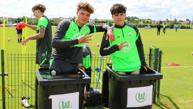 VfL Wolfsburg's U19 Spieler stehen in Eistonnen und halten Peace-Zeichen mit den Händen in die Kamera im Trainingslager in Polen.
