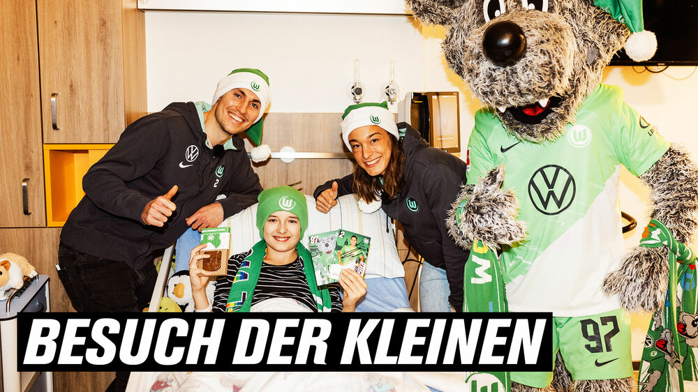 Wölfi und die VfL-Wolfsburg-Spieler Fischer und Rauch besuchen ein Mädchen im Krankenhaus.