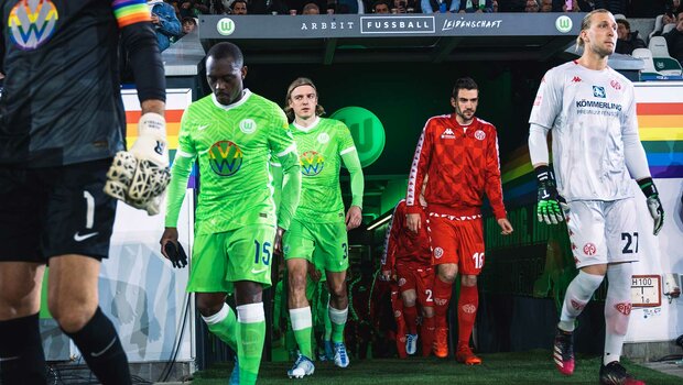 VfL Wolfsburg Spieler Jerome Roussilion und Sebastiaan Bornauw laufen am Vielfaltsspieltag in Vielfaltstrikots ein.