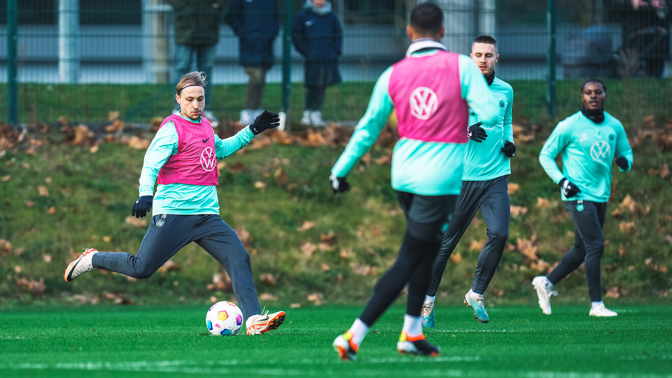VfL Wolfsburg Spieler Majer tritt mit Trainingslaibchen im Spiel gegen den Ball.