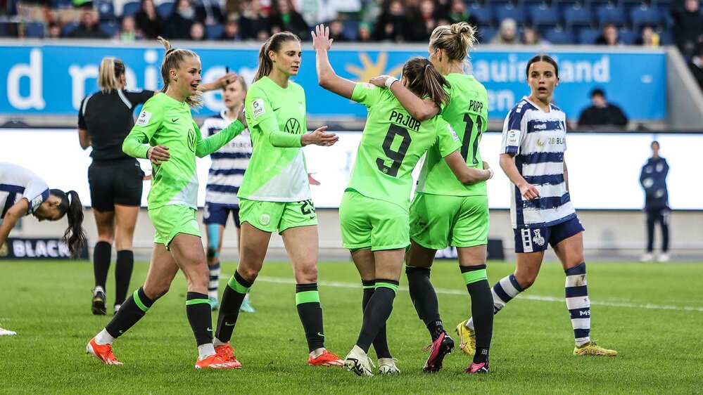 Die Spielerinnen des VfL Wolfsburg umarmen sich und bejubeln ihren Treffer. 