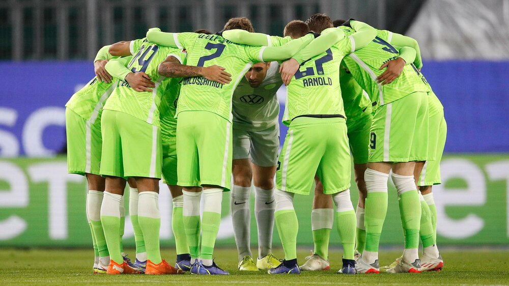 Die Profis des VfL Wolfsburg bilden einen Spielerkreis.