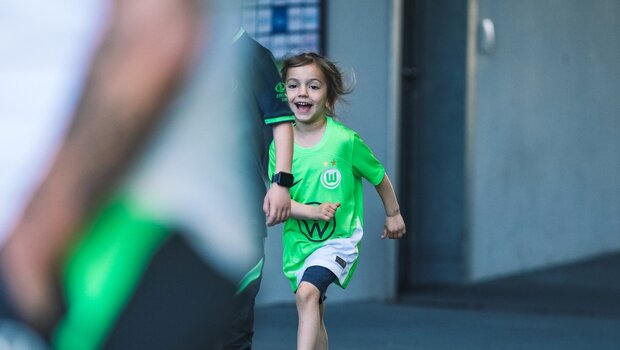 Ein Mädchen läuft zur Übernachtungsaktion des VfL Wolfsburg in die Arena.