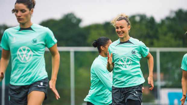 VfL-Wolfsburg-Spielerin Lena Lattwein lacht beim Aufwärmen im Training.
