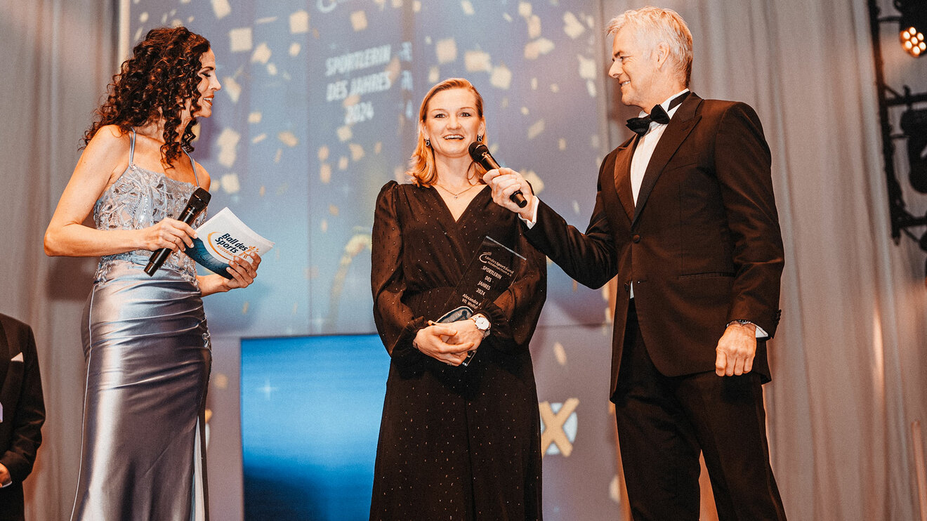 Die VfL-Wolfsburg-Spielerin Alexandra Popp hält den Preis zur Sportlerin des Jahres in den Händen und spricht in ein Mikrofon.