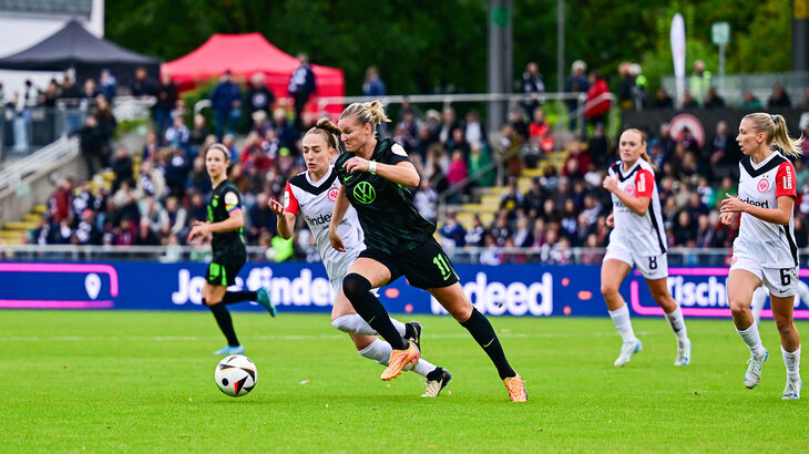 VfL-Wolfsburg-Spielerin Alexandra Popp im Duell mit Sophia Kleinherne. Beide laufend auf gleicher Höhe. Vor sich haben Sie den Ball im Visier.