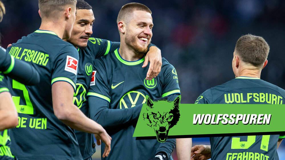 Die Mannschaft des VfL-Wolfsburg beim jubeln nach einem Tor. Auf der rechten Bildseite ist das Logo der Wolfsspuren zu sehen.